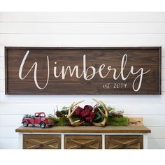 a wooden sign that says, lumber with antlers and pine cones on it next to a toy truck