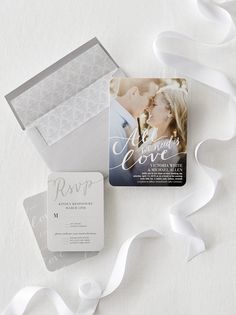 wedding stationery and save the date cards on white paper with ribbon streamers around them