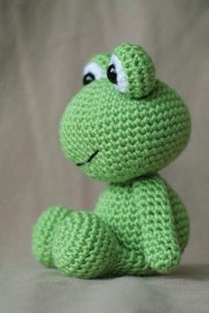 a green crocheted frog sitting on top of a table