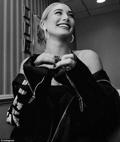 black and white photograph of a woman in a room smiling with her hands on her hips