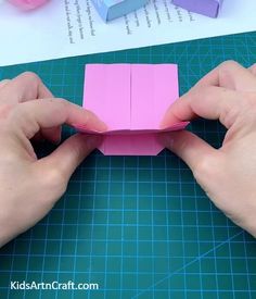 someone is making an origami box out of paper