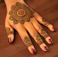 a woman's hand with henna tattoos on it