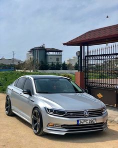 a silver car parked in front of a gate