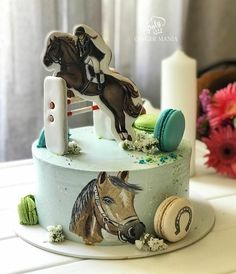 a decorated cake with horse and jockey figures on it's top, sitting on a table