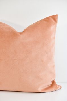 an orange pillow sitting on top of a white table