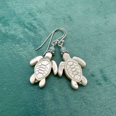 Cute sea turtles carved from mother of pearl shells. The Mother of Pearl is made up of white nacre and has a beautiful rainbow of color reflected when the light hits them just right. I accented the cute turtles with light blue larimar stones. They dangle from silver ear wires. All metal is solid 925 sterling silver. The earrings are ready for shipping and will be shipped within 24-72 hours from purchase. You will receive the earrings in a gift box with a ribbon. -------- FREE silver polishing cloth is included with all orders of $20 or more. Larimar Stone, Cute Turtles, Sea Turtles, Pearl Shell, Beautiful Rainbow, Sea Turtle, Turtles, Solid 925 Sterling Silver, Mother Of Pearl