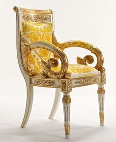 an ornate chair with gold and white paint on it's back legs, sitting in front of a white background