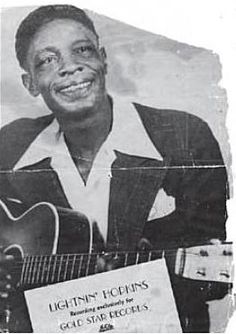 a black and white photo of a man holding a guitar