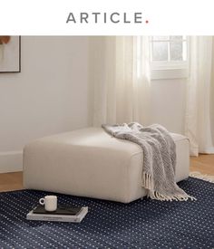 a white couch sitting on top of a blue rug