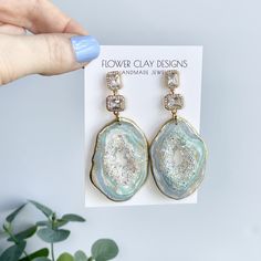 THESE ARE STUNNING IN PERSON! It's difficult to show you how gorgeous these really are. Double sided Rainbow Agate with beautiful rhinestone geode centers. Perfect for a wedding, as a bride or for the agate/geode statement earring wearer.  Handmade polymer clay Agate geode druzy dangle earrings. Cubic Zirconia stud and charm. Sparkly rock technique geode centers that sparkle with iridescent colors. Double sided. This gives the geode center its beauty!  Approximately 3.25 inches Each agate/ geode Rainbow Agate, Geode Wedding, Geode Jewelry, Druzy Earrings, Statement Earring, Agate Geode, Druzy Agate, Clay Ideas, Earrings Blue