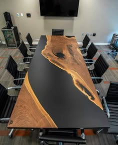 a conference room with black chairs and a large wooden table that has been designed to look like an ocean wave