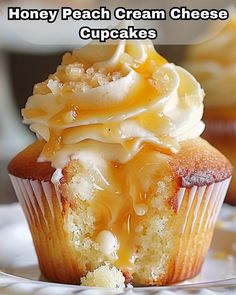 a close up of a cupcake on a plate with the words honey peach cream cheese cupcakes