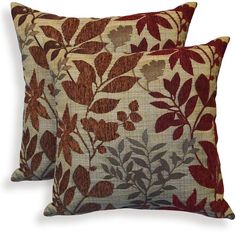 a decorative pillow with red and brown leaves on the front, sitting on a white background