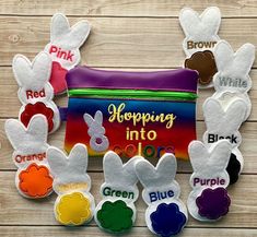 an assortment of felt easter bunnies sitting on top of a wooden table next to a bag