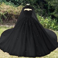 a black ball gown on display in the grass