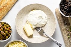 an assortment of food including olives, cheese and bread