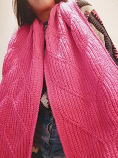 a woman wearing a pink sweater and scarf