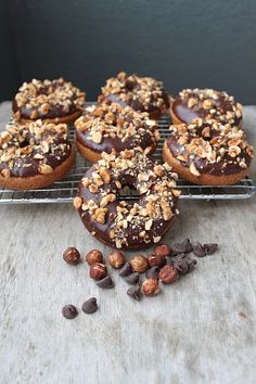 chocolate covered doughnuts with nuts on a cooling rack