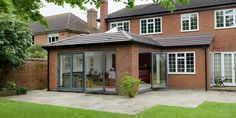 a large brick house with glass doors and windows