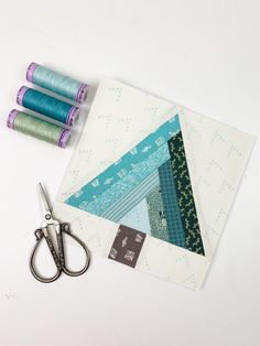 sewing supplies including scissors and thread on a white surface