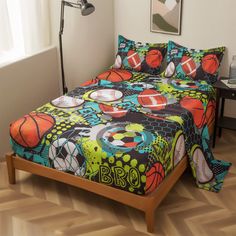 a bed with a colorful comforter and pillows on it in front of a window