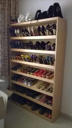 a wooden shoe rack filled with lots of shoes