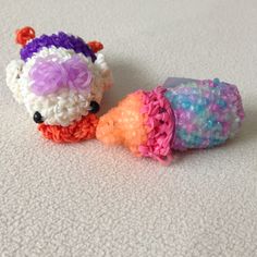 two small crocheted animals sitting next to each other on a white carpeted floor