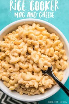 a white bowl filled with macaroni and cheese on top of a blue table