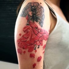 a woman's arm with red roses and an angel on the back of it