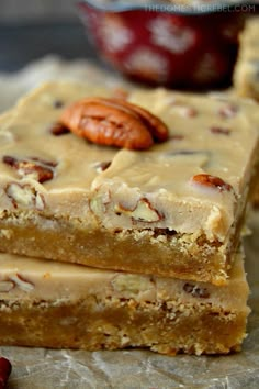 three pieces of food sitting on top of a piece of wax paper next to nuts