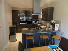 a kitchen with an island, stove and chairs