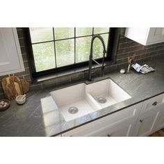 a kitchen sink with two faucets in the middle and a window behind it