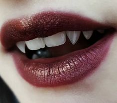 a close up shot of a woman's mouth with red lipstick and white teeth