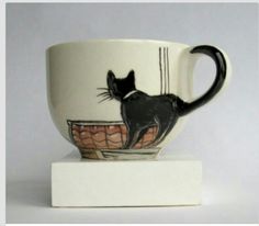 a coffee cup with a black cat on it