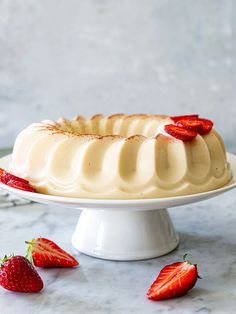 a cake on a plate with strawberries around it