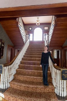 a woman standing at the bottom of stairs