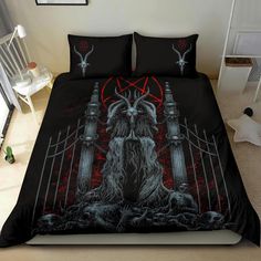 a bed with a black and red cover that has an image of a demon on it