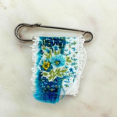 a blue and white towel hanging from a metal hook