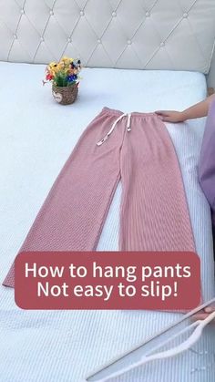 a woman laying on top of a bed next to a pair of scissors and pink pants