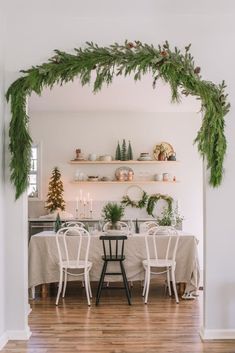 the dining room table is decorated with greenery