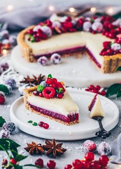 two slices of cheesecake with berries on top and one slice missing from the pie