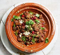 a bowl filled with meat and vegetables on top of a table