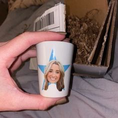 a hand holding a coffee cup with a photo on it