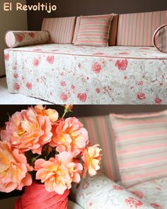 a couch with pink flowers in a vase next to the same couch and pillows on it