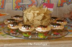 an assortment of snacks and condiments on a platter at a birthday party