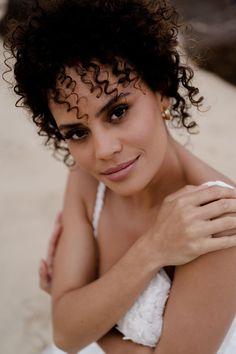 a close up of a person wearing a dress and posing for the camera with her arms crossed