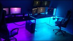 a computer desk topped with two monitors and a keyboard next to a chair in a room