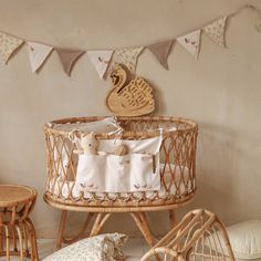 a wicker crib with two teddy bears in it and some pillows on the floor