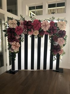 a black and white striped wall with flowers on it