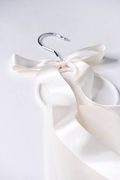 a pair of scissors on top of a white cloth with a ribbon tied around it